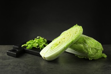 Photo of Whole and cut fresh Chinese cabbages on grey table