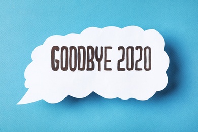 Photo of Paper speech balloon with phrase Goodbye 2020 on light blue background