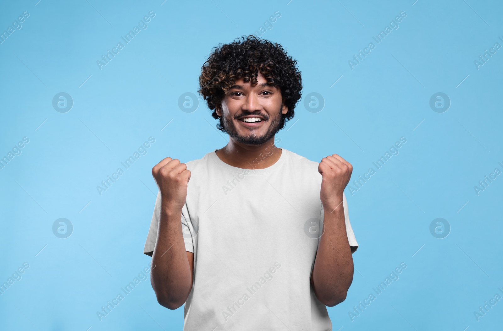 Photo of Handsome happy man on light blue background