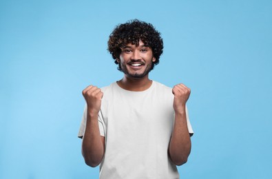 Photo of Handsome happy man on light blue background