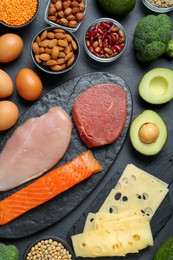Photo of Different fresh products on black table, flat lay. Sources of essential amino acids