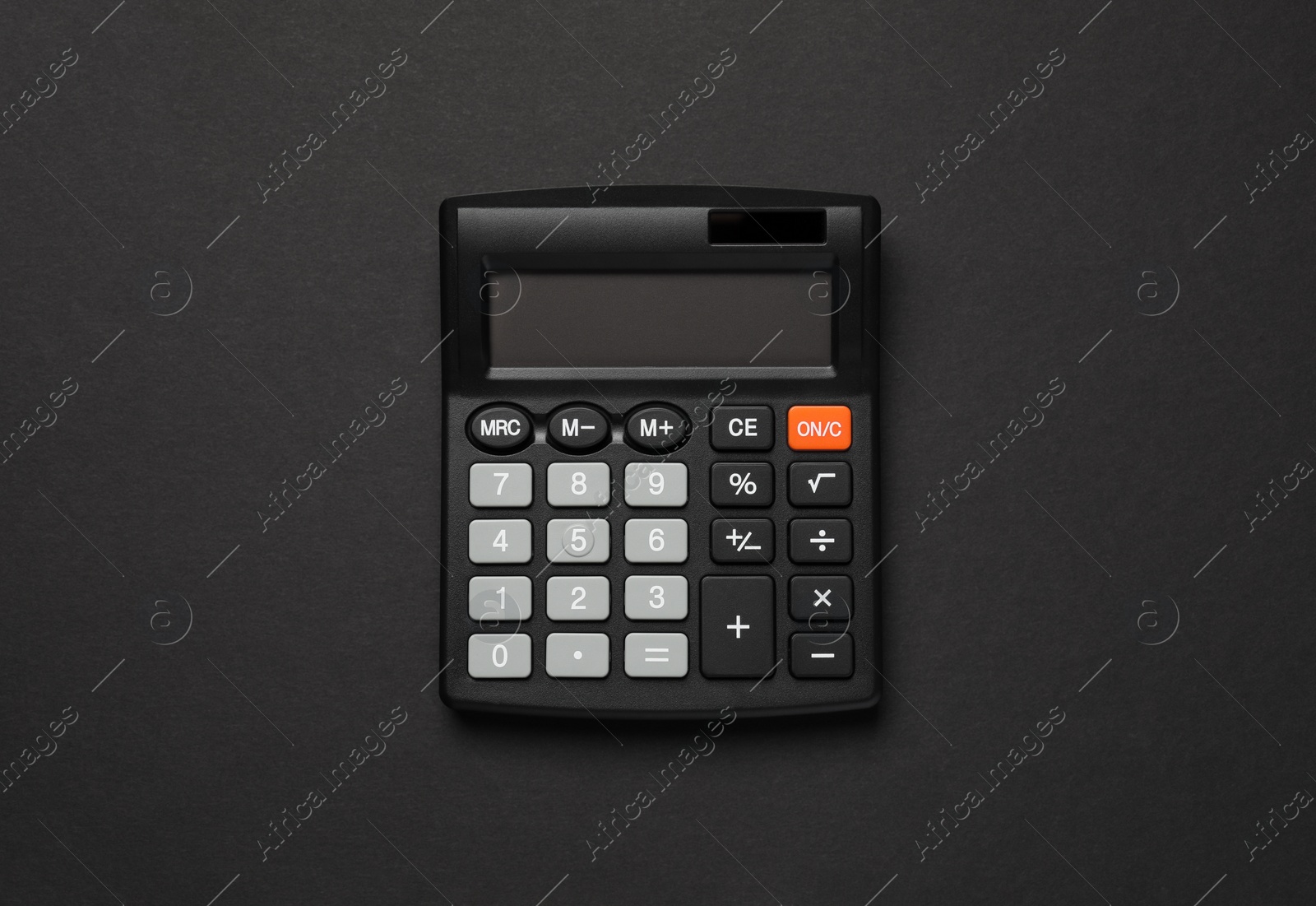 Photo of Calculator on black background, top view. Office stationery