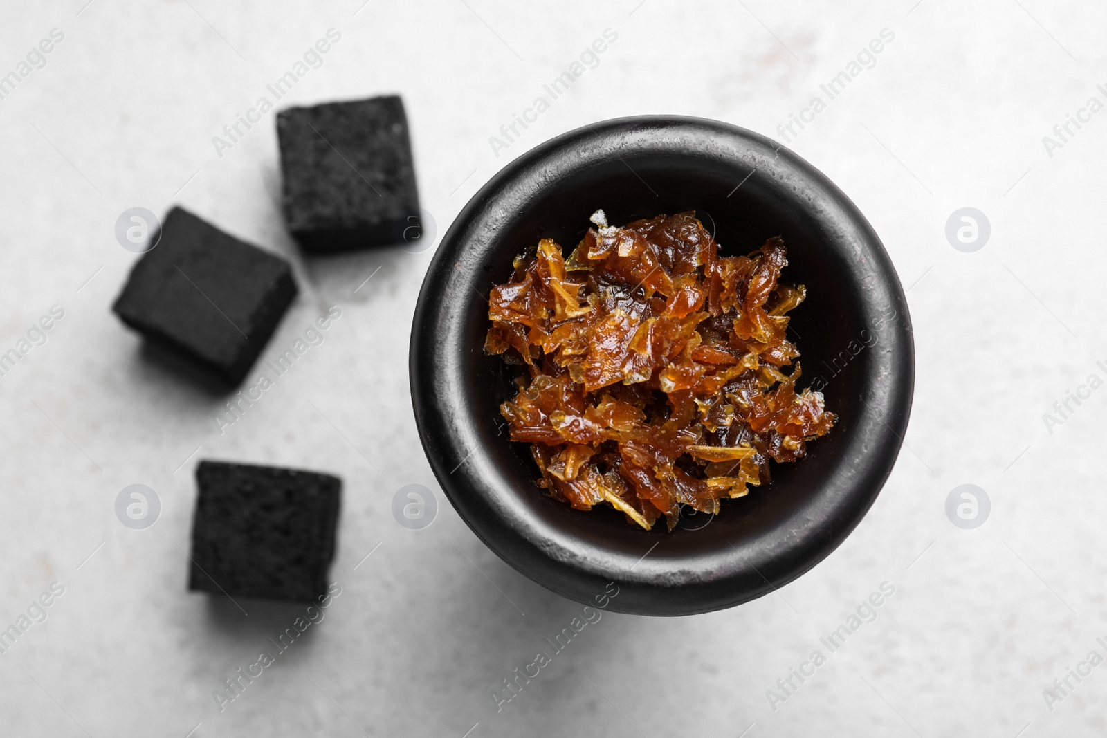 Photo of Modern hookah bowl with tobacco and charcoal cubes on light grey table, flat lay