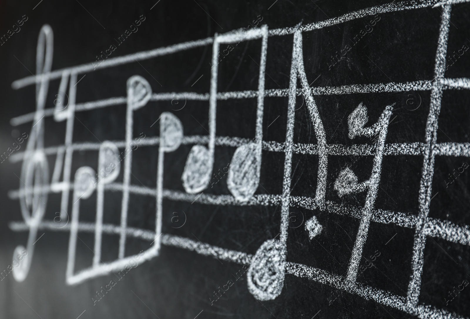 Photo of Music staff with treble clef and notes written on chalkboard