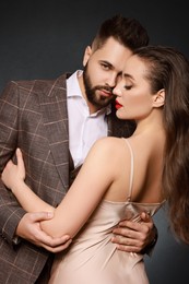 Photo of Handsome bearded man with sexy lady on grey background