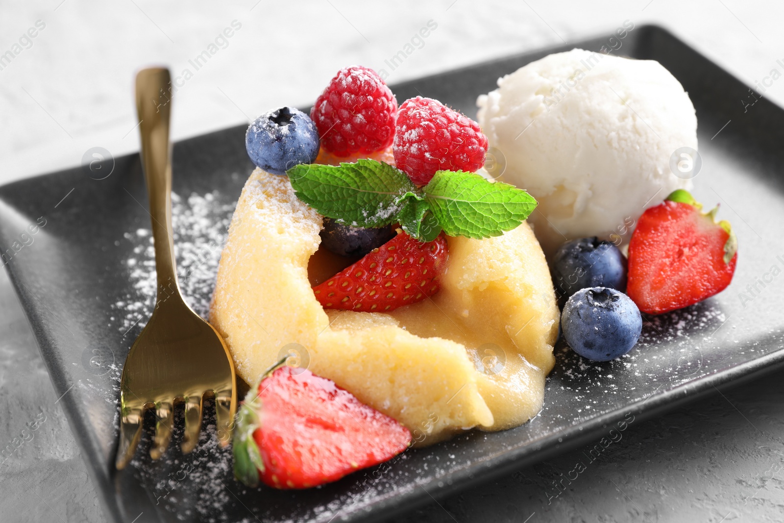 Photo of Tasty vanilla fondant with white chocolate and berries on table, closeup