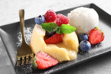 Tasty vanilla fondant with white chocolate and berries on table, closeup