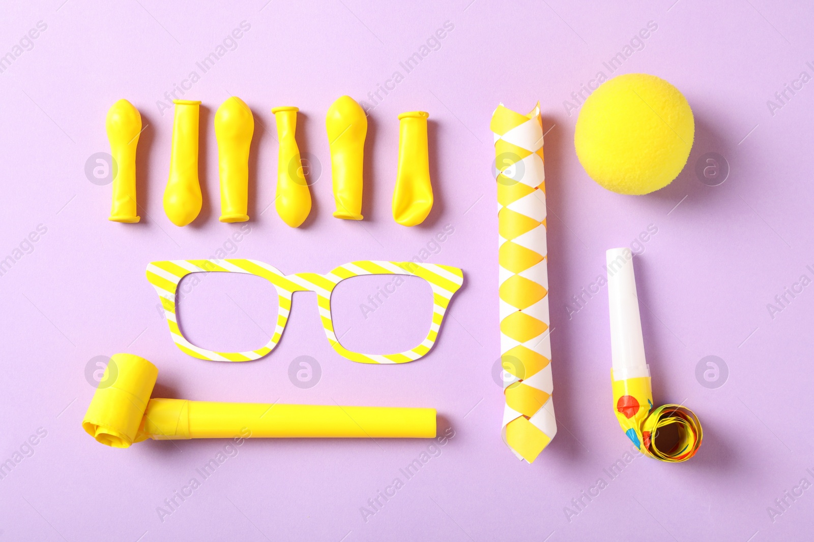 Photo of Different clown's accessories on lilac background, flat lay