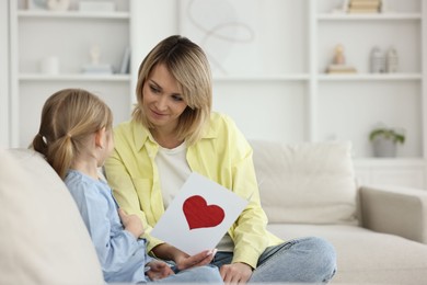 Photo of Little daughter congratulating her mom with greeting card at home, space for text. Happy Mother's Day