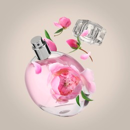 Bottle of perfume and peonies in air on dark beige background. Flower fragrance
