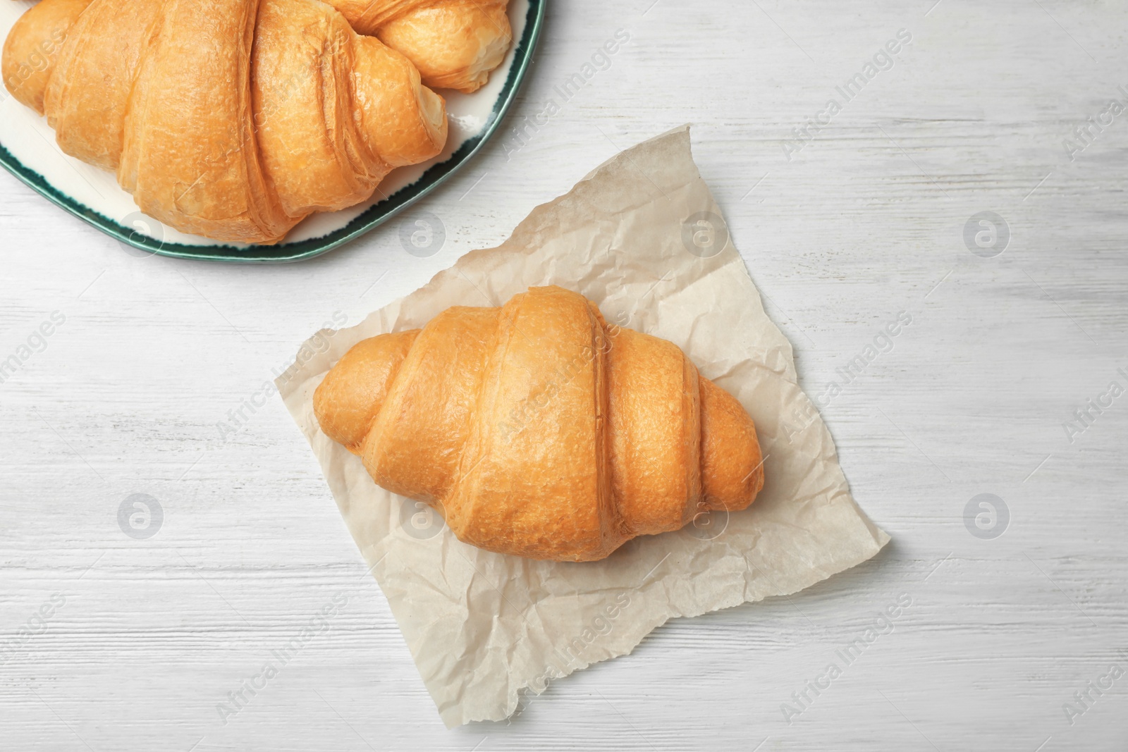 Photo of Tasty croissant on wooden background, top view