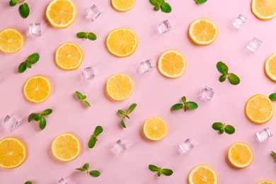 Photo of Lemonade layout with juicy lemon slices, mint and ice cubes on pink background, top view