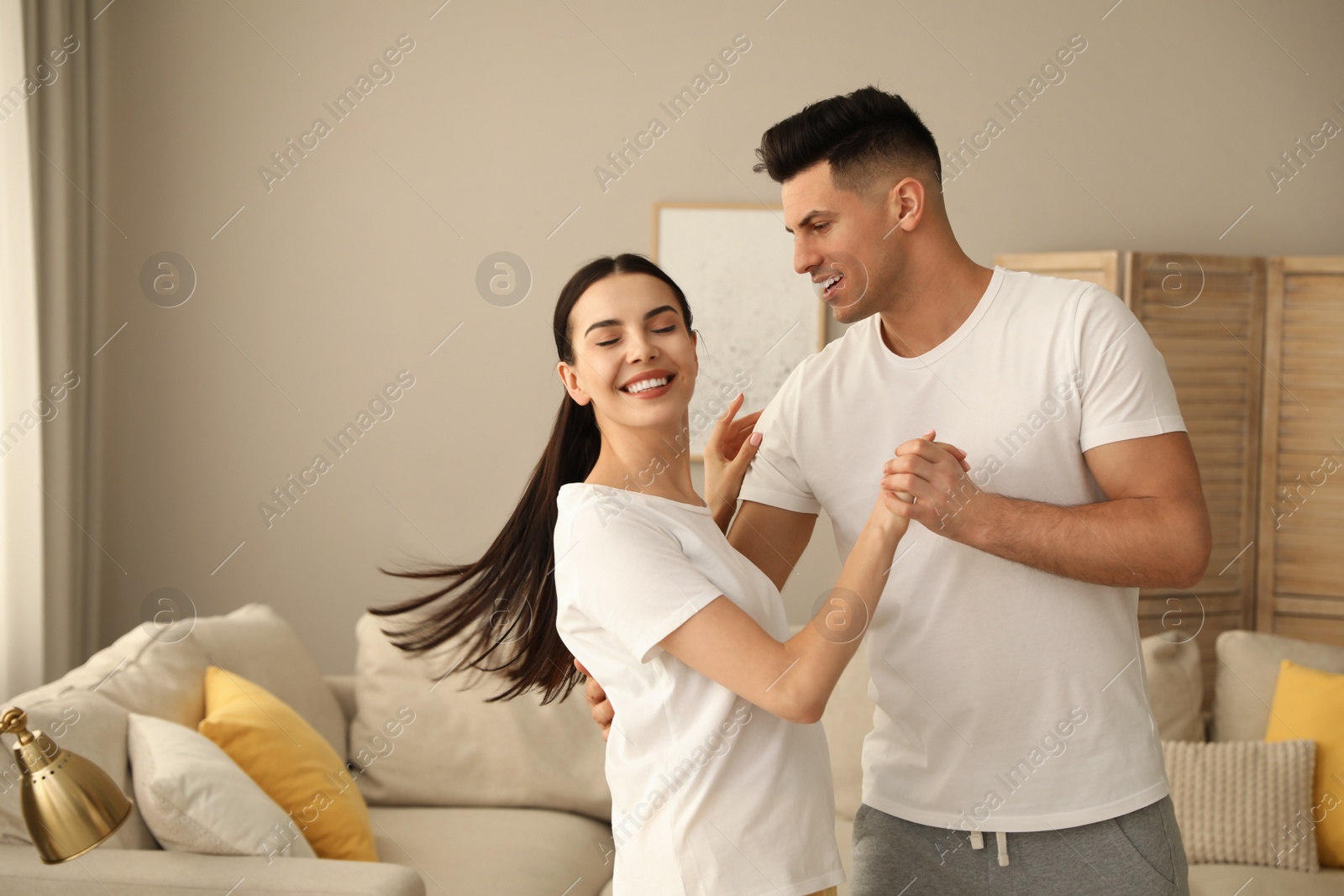 Photo of Happy couple in pyjamas dancing at home