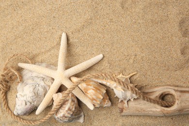 Photo of Beautiful starfish, rope and sea shells on sand, flat lay. Space for text
