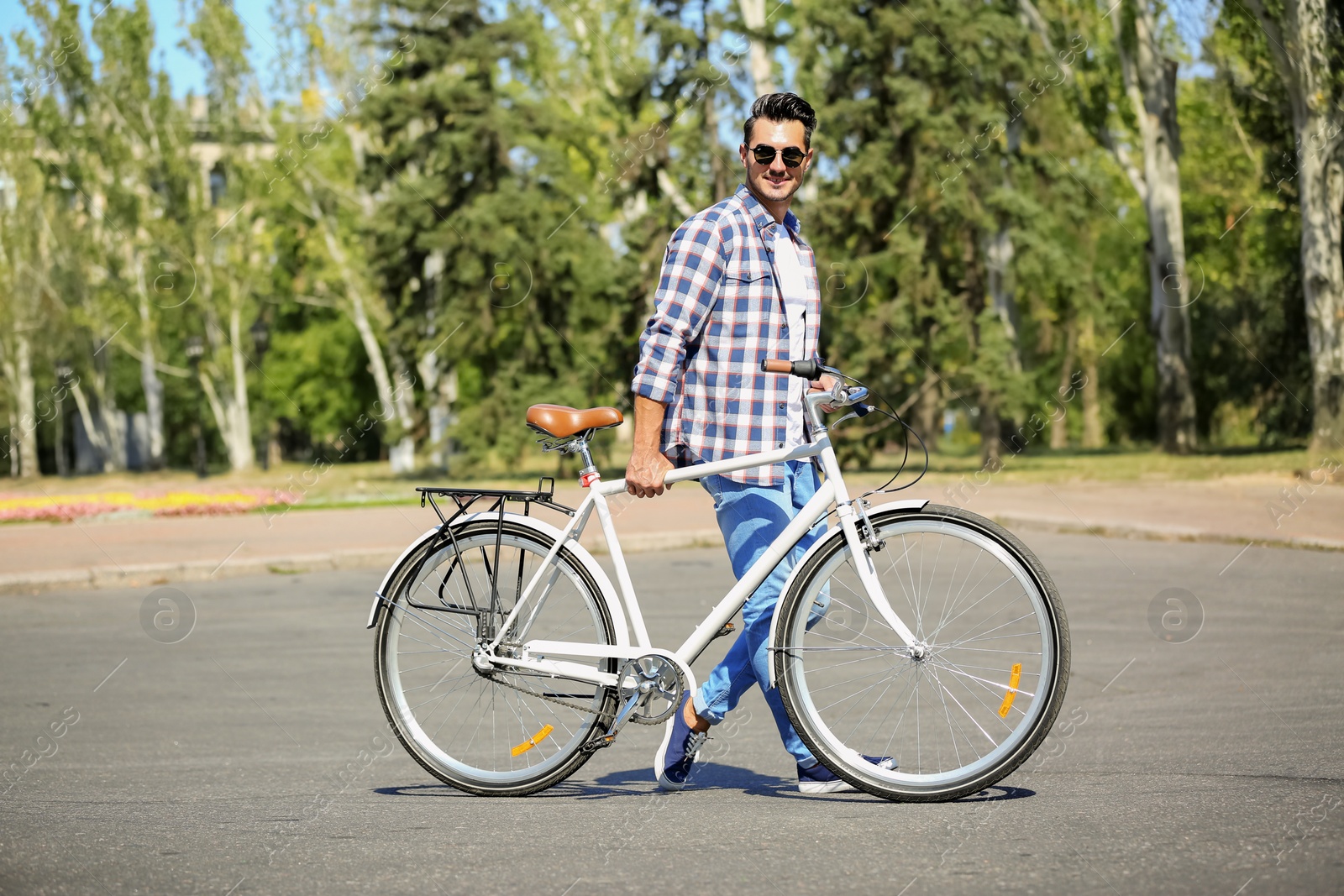 Photo of Handsome young hipster man with bicycle outdoors