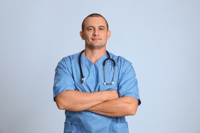 Portrait of medical assistant with stethoscope on color background