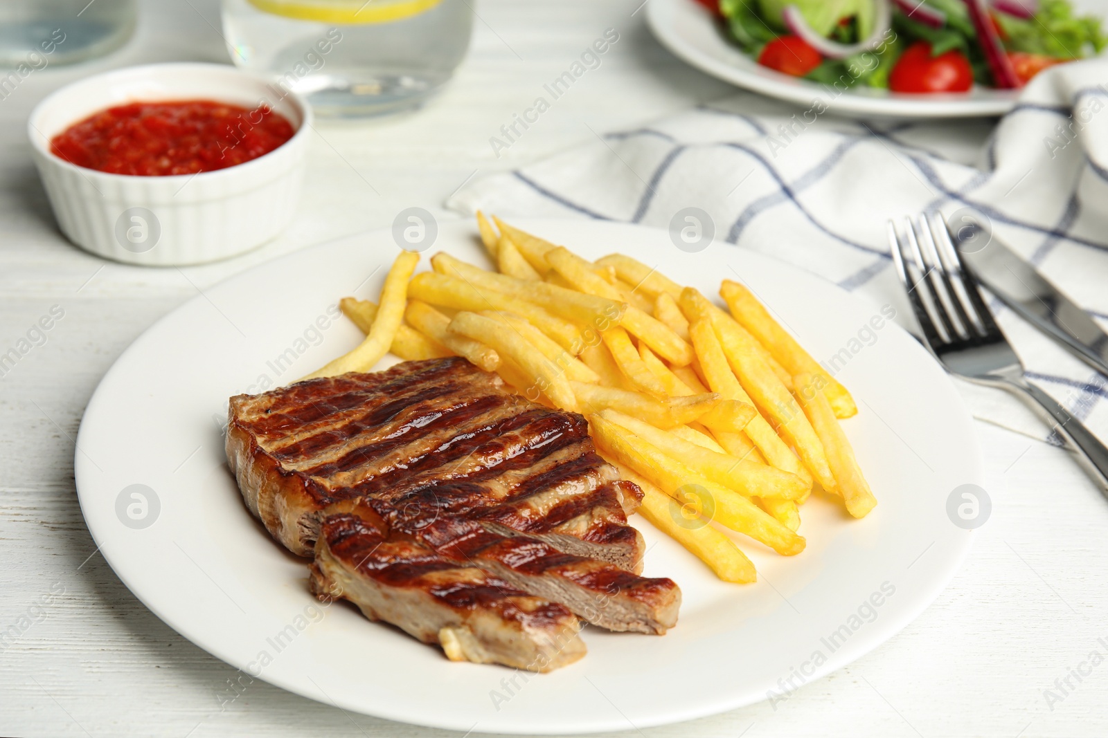Image of Grilled steak with French fries on white table