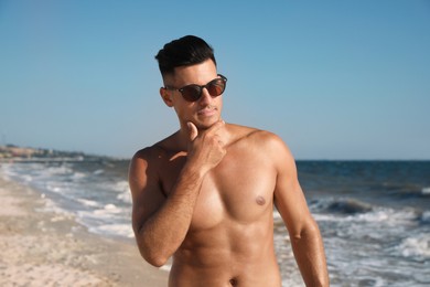 Photo of Handsome man with attractive body on beach
