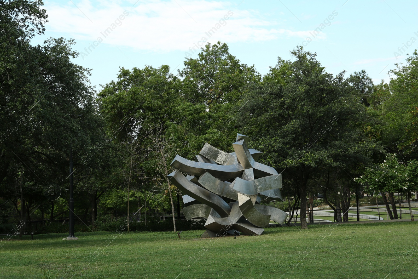 Photo of Picturesque view of beautiful park with metal figure on green grass