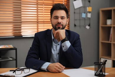 Photo of Portrait of young businessman at desk in office