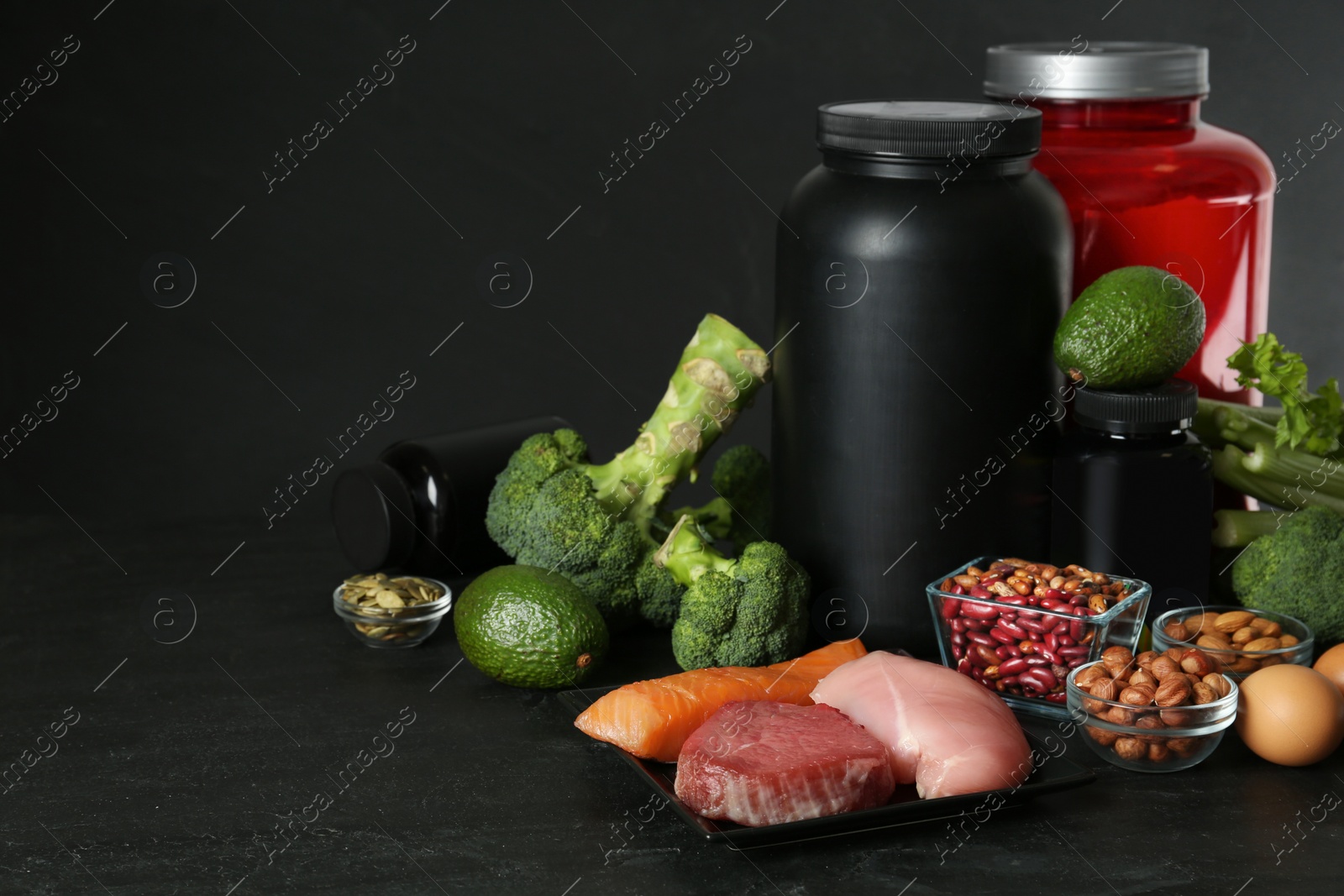 Photo of Set of products rich in amino acids and supplements on black table. Space for text