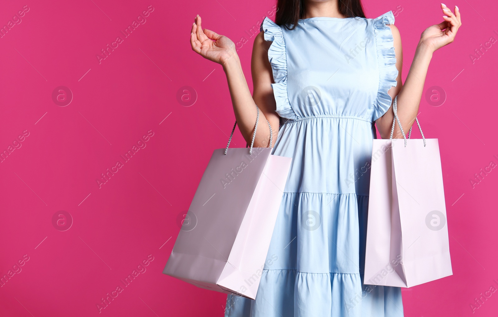 Photo of Woman with blank paper bags against color background, closeup. Space for text