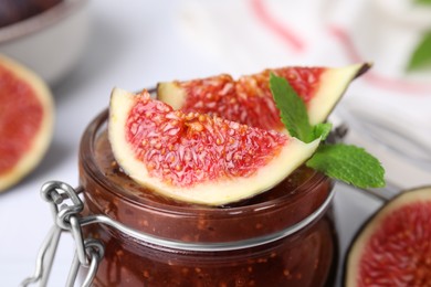 Tasty sweet fig jam and fruits on table, closeup