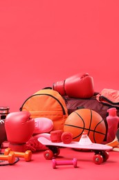 Photo of Many different sports equipment on red background, space for text