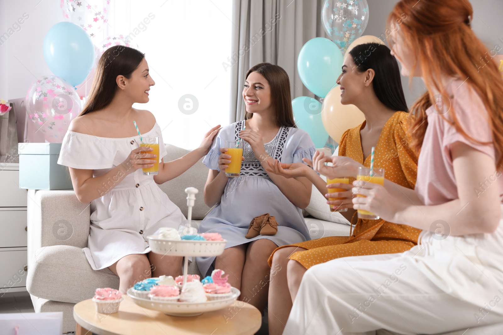 Photo of Happy pregnant woman spending time with friends at baby shower party