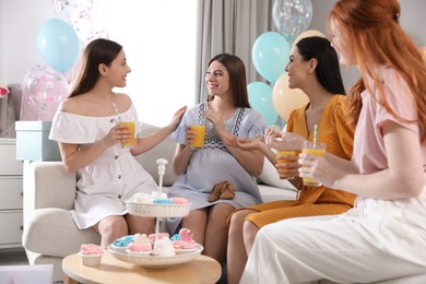 Happy pregnant woman spending time with friends at baby shower party