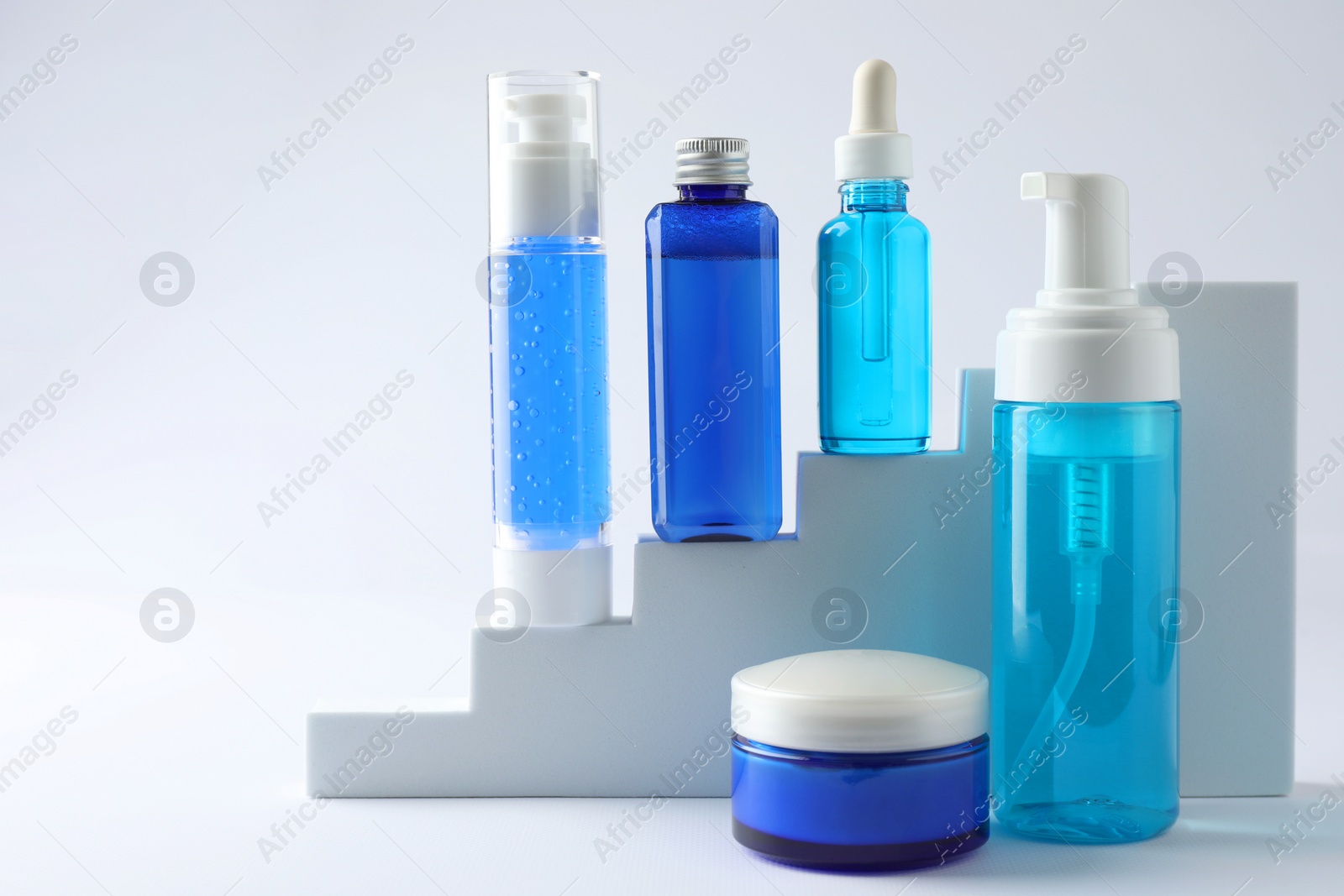 Photo of Set of luxury cosmetic products on stairs against white background. Space for text