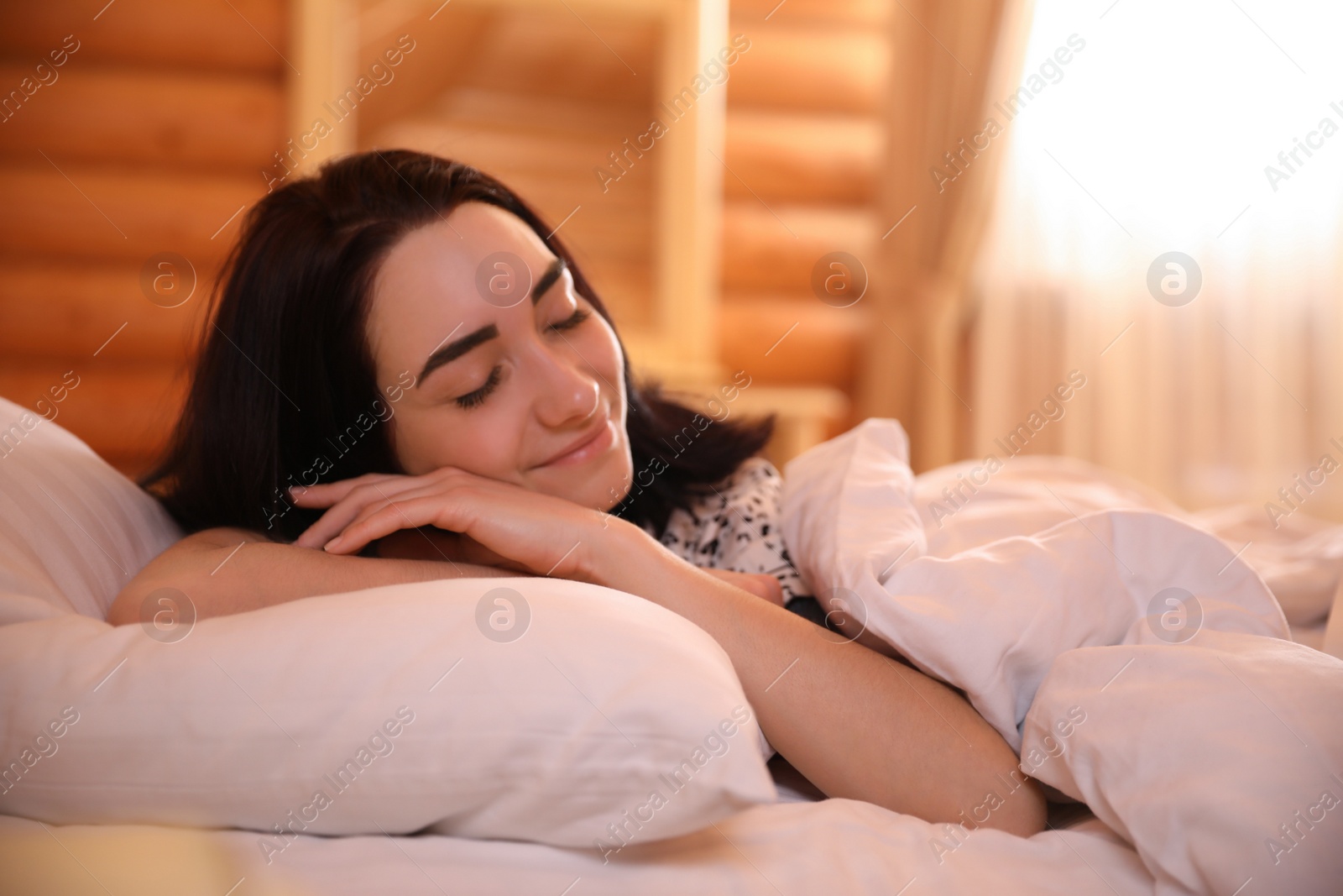 Photo of Young woman sleeping in bed at home. Lazy morning