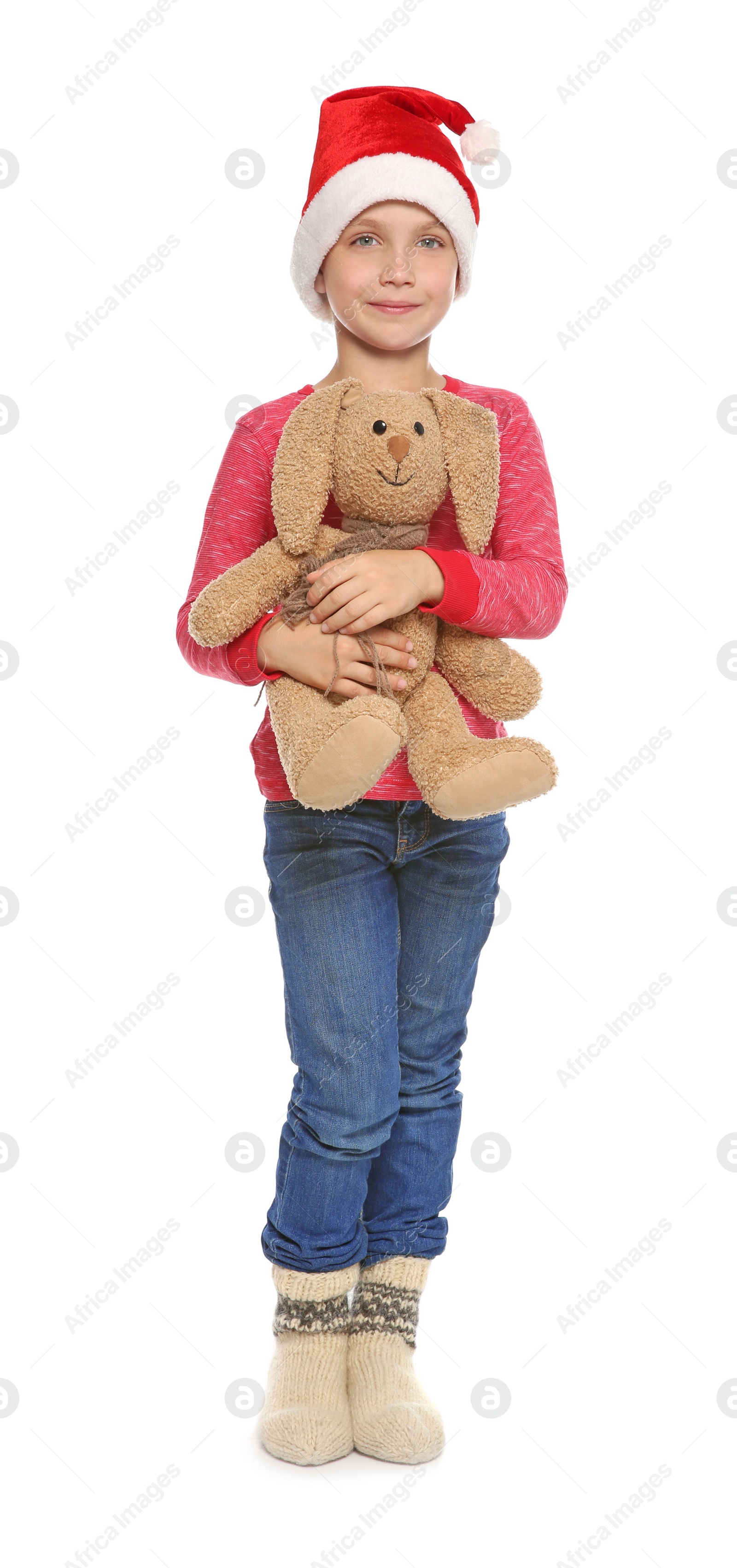 Photo of Cute little child in Santa hat with toy rabbit on white background. Christmas celebration