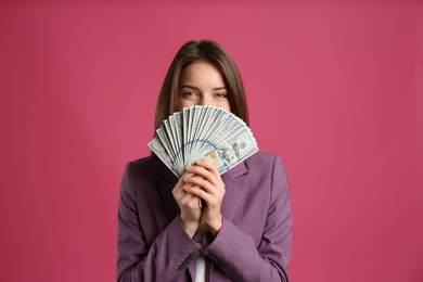 Photo of Young woman with cash money on pink background
