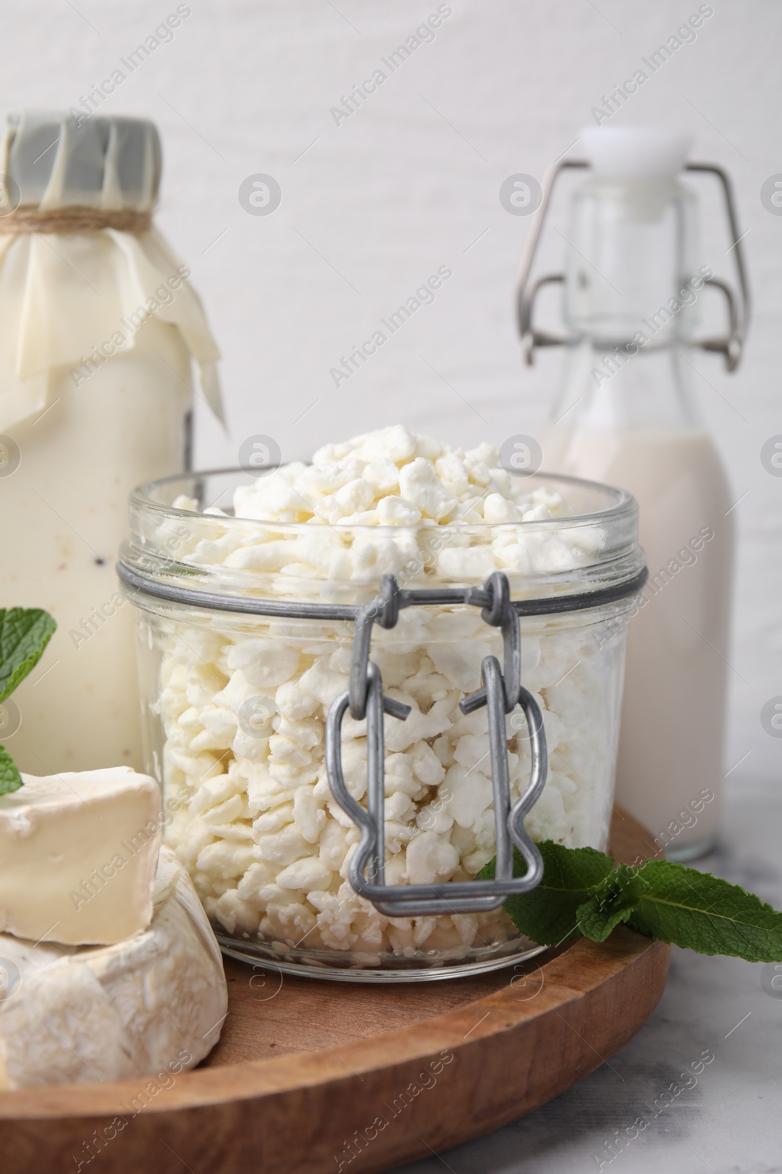 Photo of Different dairy products and mint on white marble table