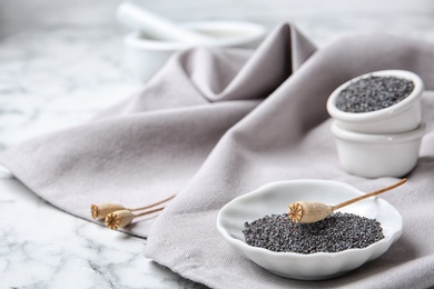 Photo of Composition with poppy seeds on grey fabric