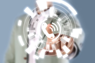 Image of Hotline service. Man pointing at virtual icon with telephone symbol, closeup