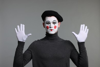 Photo of Mime artist in beret posing on grey background