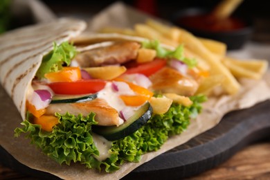 Photo of Delicious chicken shawarma on wooden table, closeup