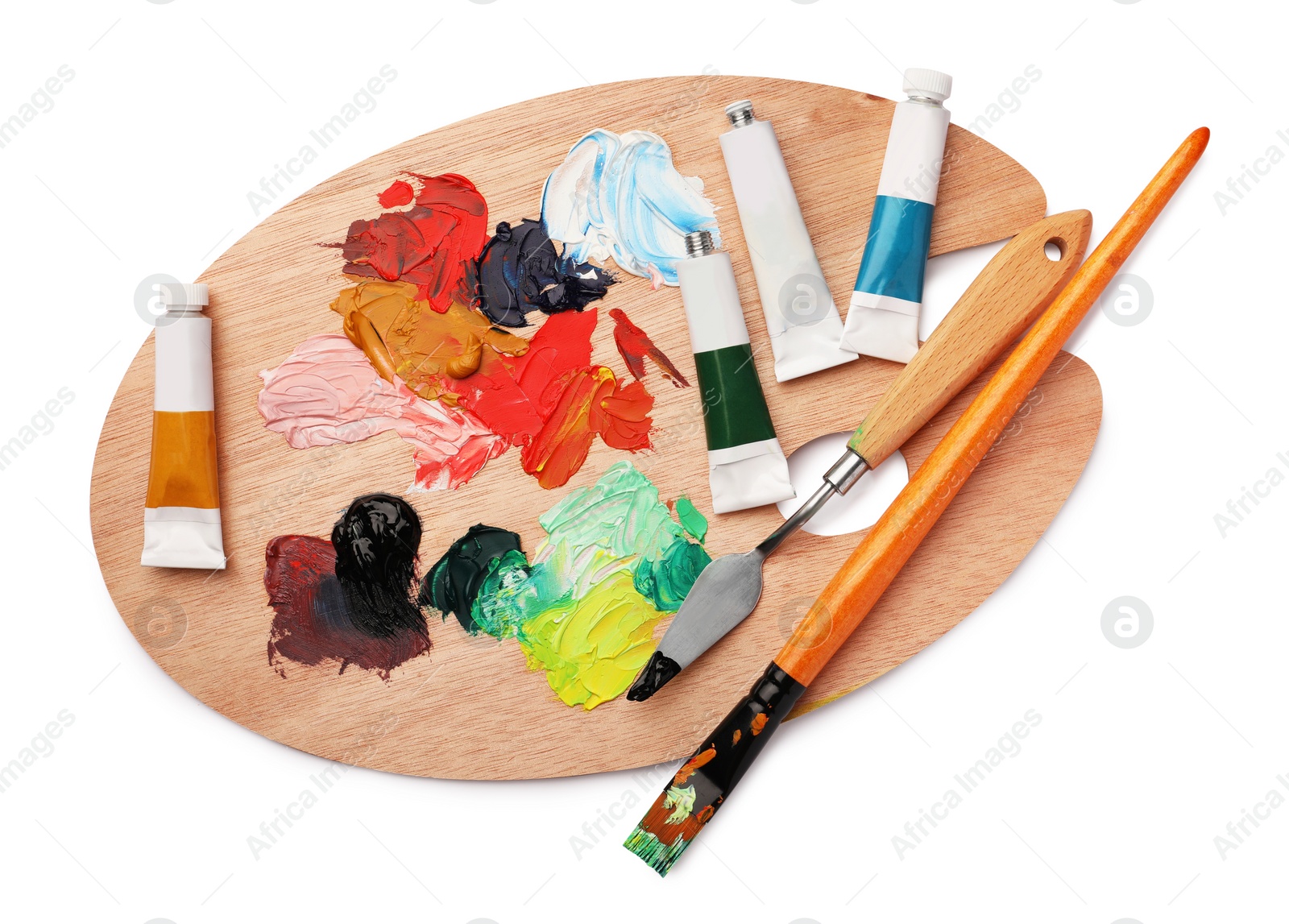 Photo of Wooden palette with oil paints and tools on white background, top view