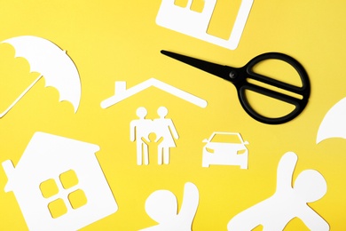 Flat lay composition with paper silhouette of family and scissors on color background. Life insurance concept