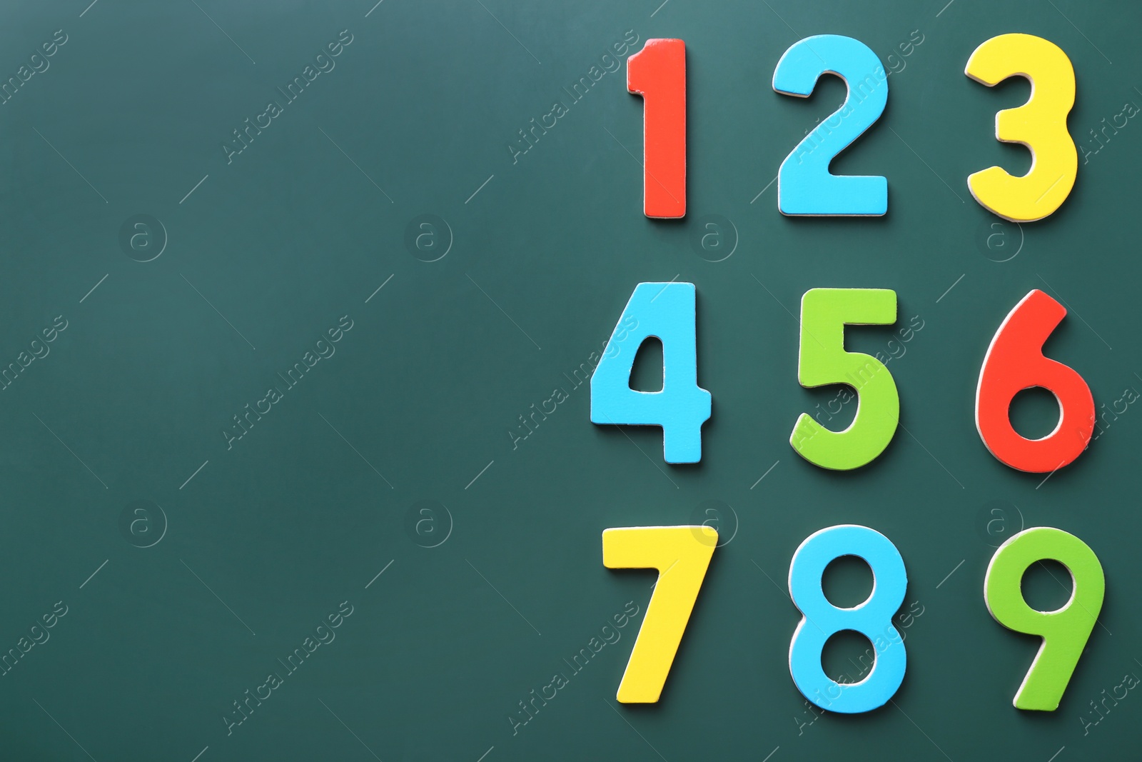 Photo of Colorful numbers on green background, flat lay. Space for text