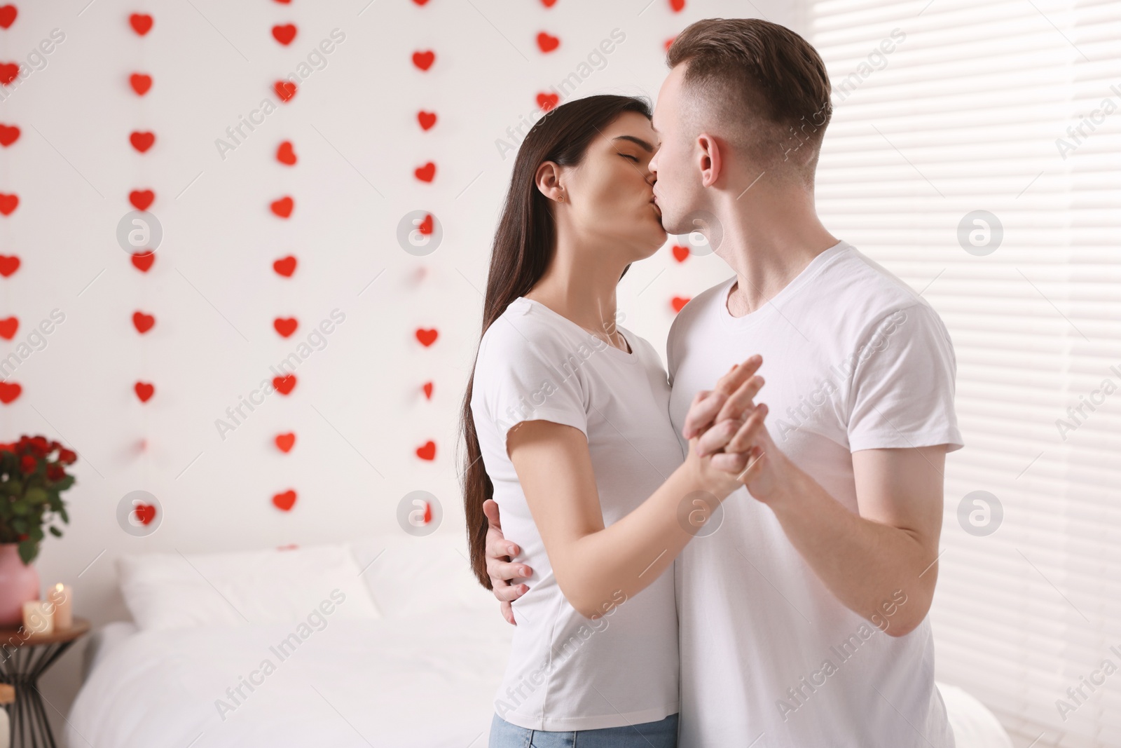 Photo of Lovely couple kissing at home, space for text. Valentine`s day celebration