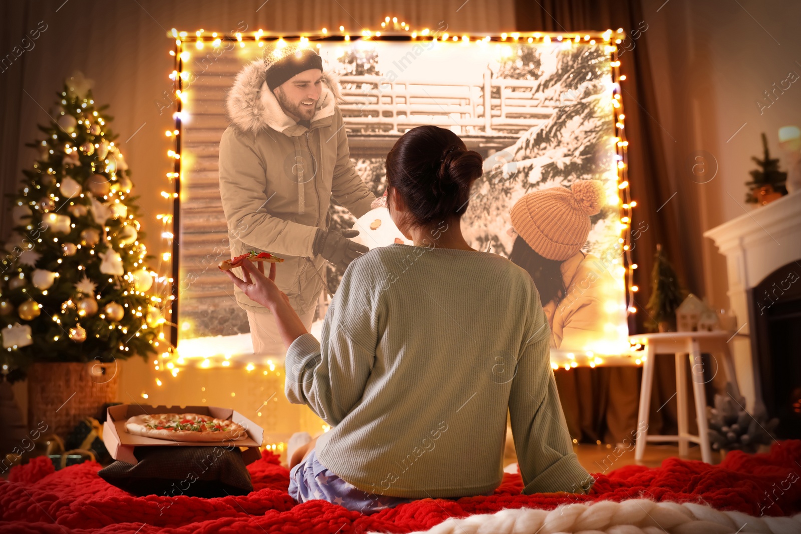 Image of Woman watching romantic movie via video projector in room. Cozy winter holidays atmosphere