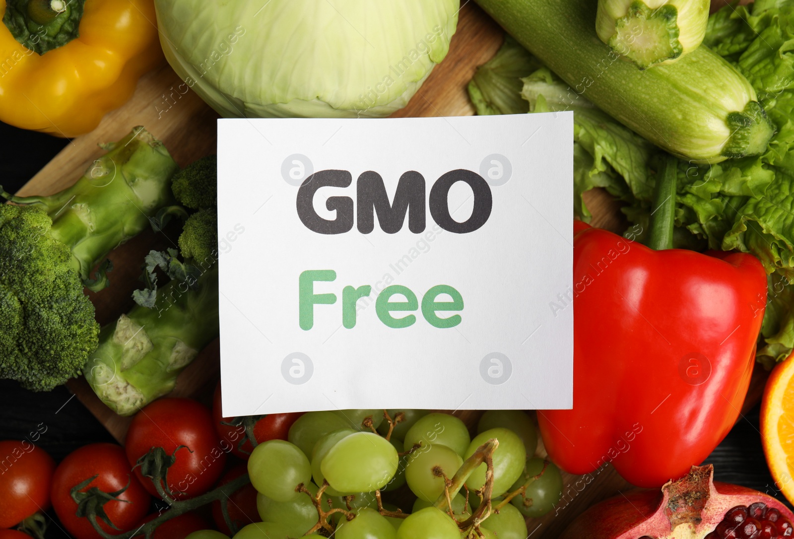 Photo of Tasty fresh GMO free products and paper card on table, top view