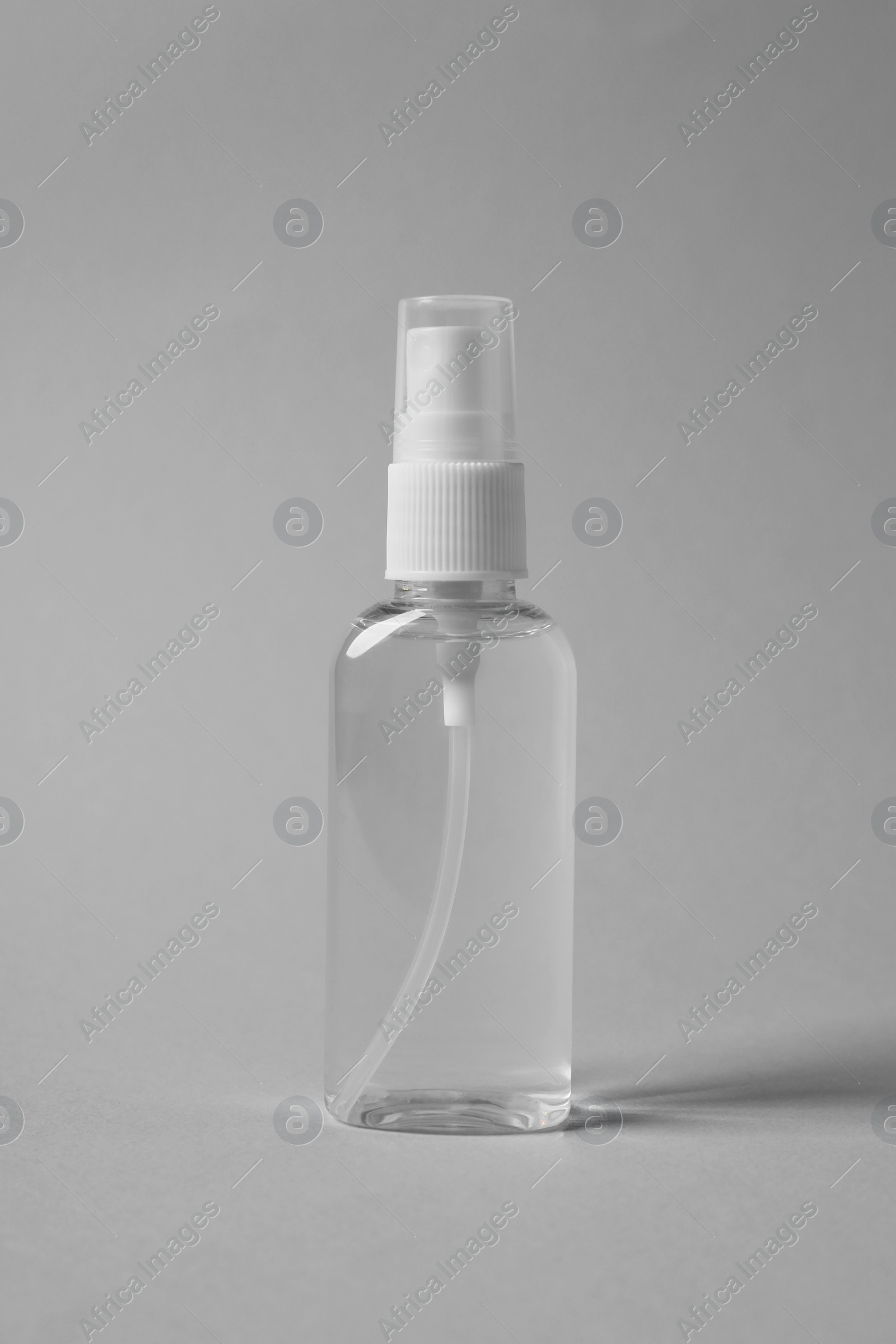 Photo of Transparent bottle of cosmetic product on grey background