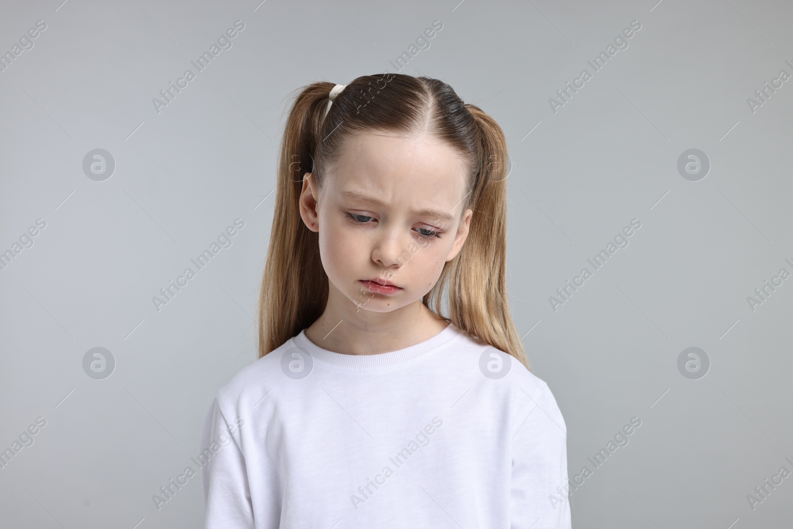 Photo of Portrait of sad girl on light grey background