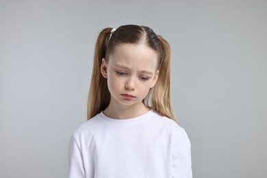 Photo of Portrait of sad girl on light grey background