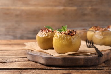 Tasty baked apples served on wooden table