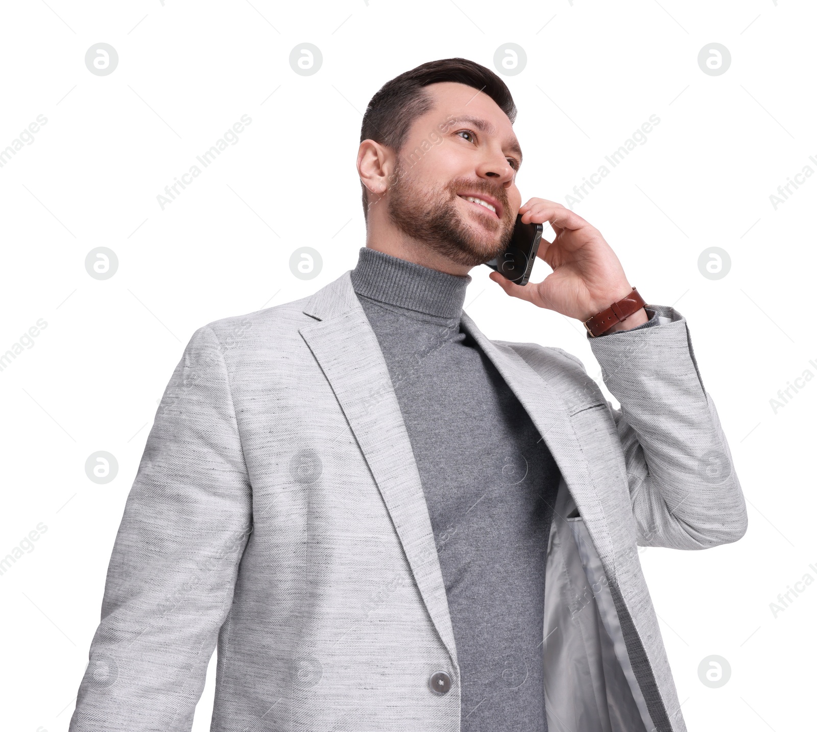 Photo of Handsome bearded businessman talking on smartphone against white background, low angle view